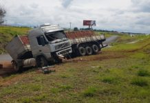 Motorista perde controle ao passar por mancha de óleo e caminhão cai em barranco