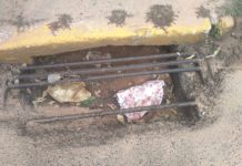 Bueiro está entupido com terra e grade está quebrada