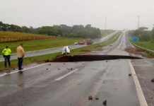 Equipes de resgate fazem buscas por caminhão que sumiu ao cair em cratera aberta em rodovia durante chuva